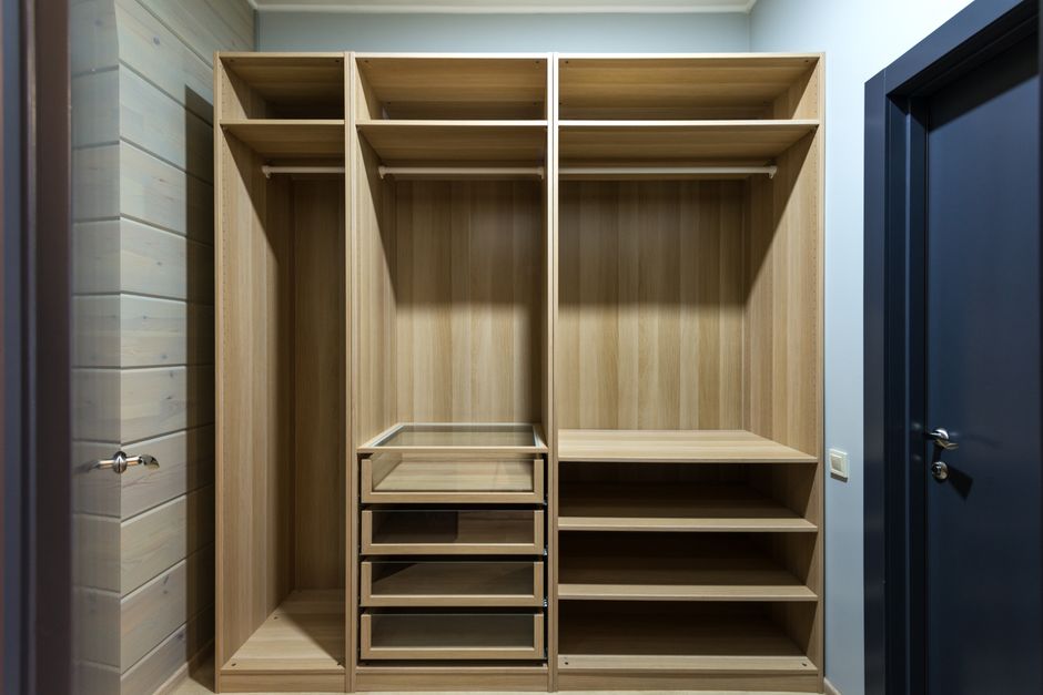 Modern reach-in closet with wooden drawers and shelving